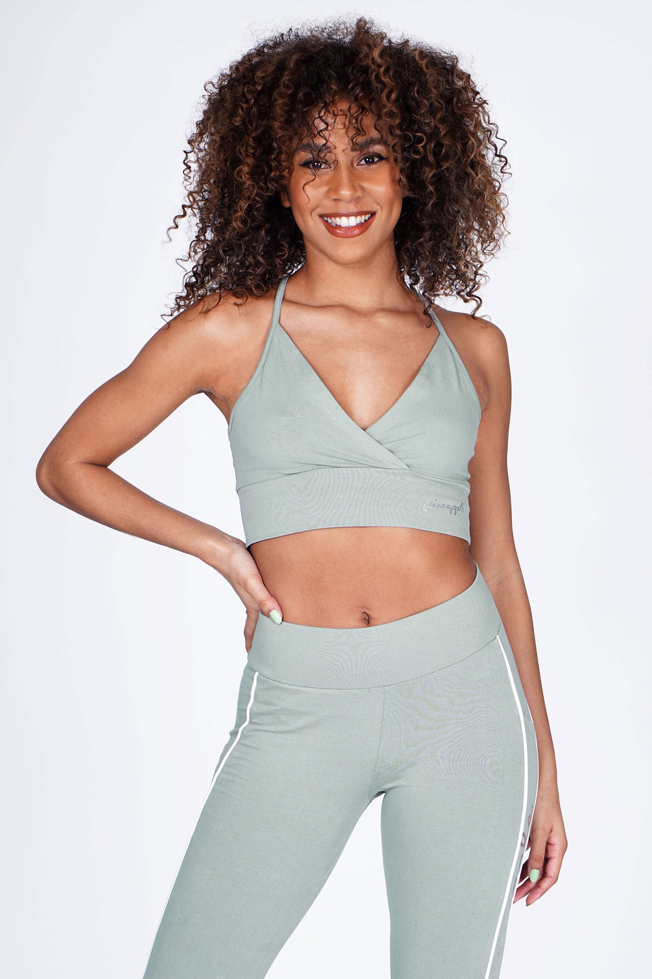 Woman wearing Pineapple sage Green 'V' Wrap Crop Top with sage green leggings
