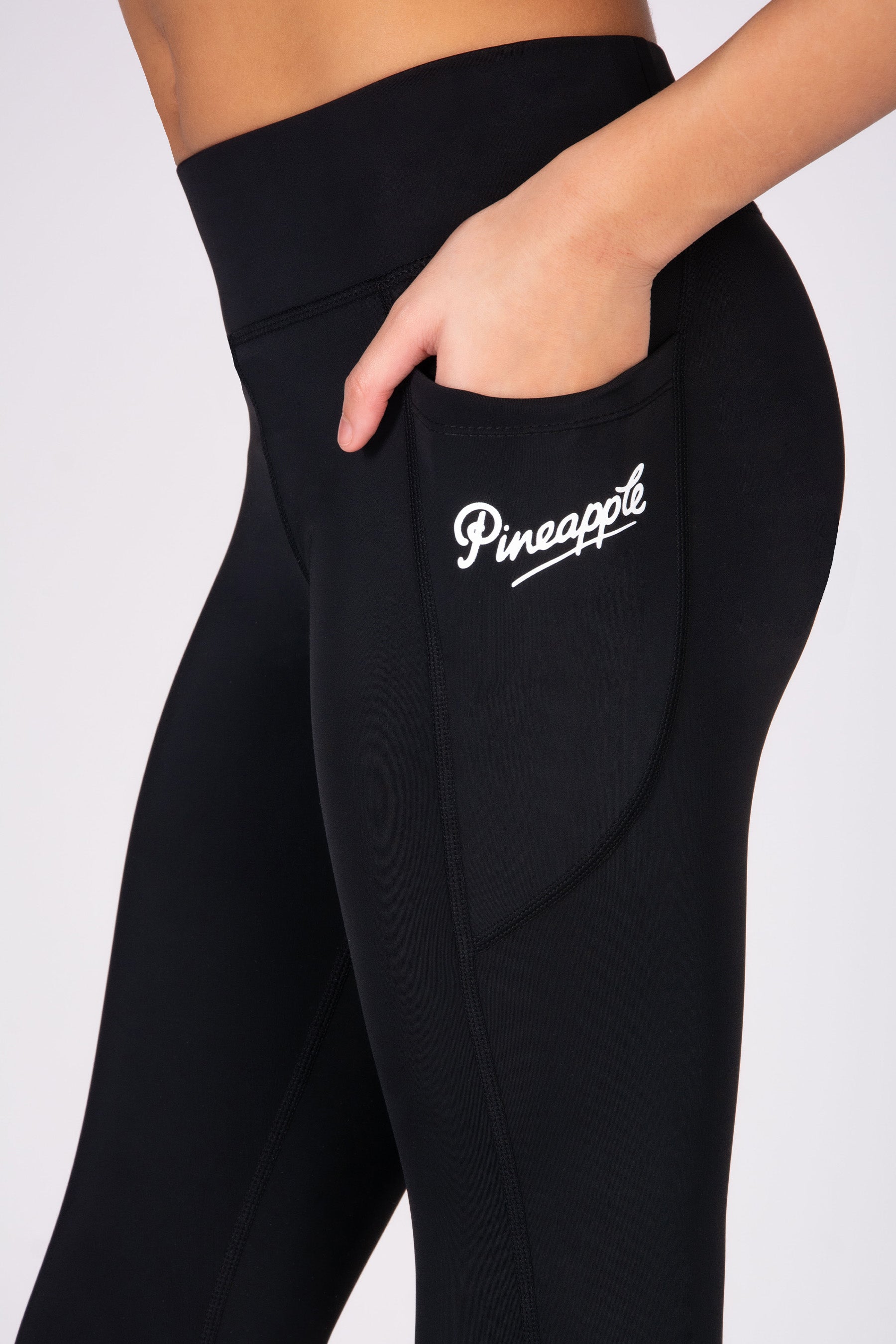 Black leggings with 'Pineapple' logo on a white background