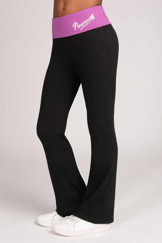 Black flared leggings with a light purple waistband featuring the silver logo 'Pineapple' against a light grey studio background.