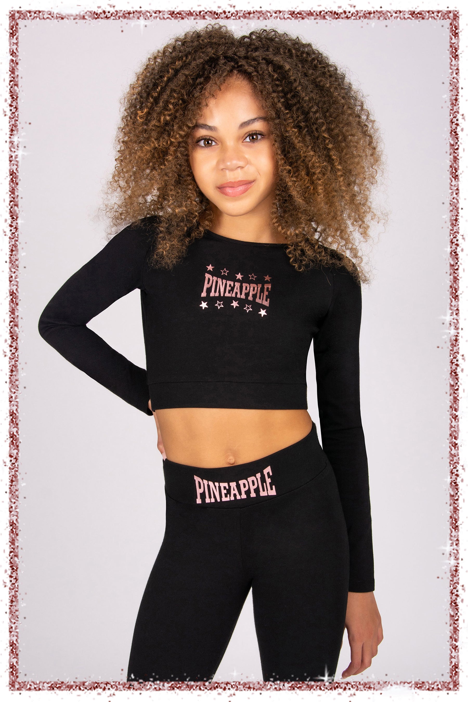 Girl wearing a black long-sleeve crop top and leggings with 'Pineapple' branding on a light grey background.