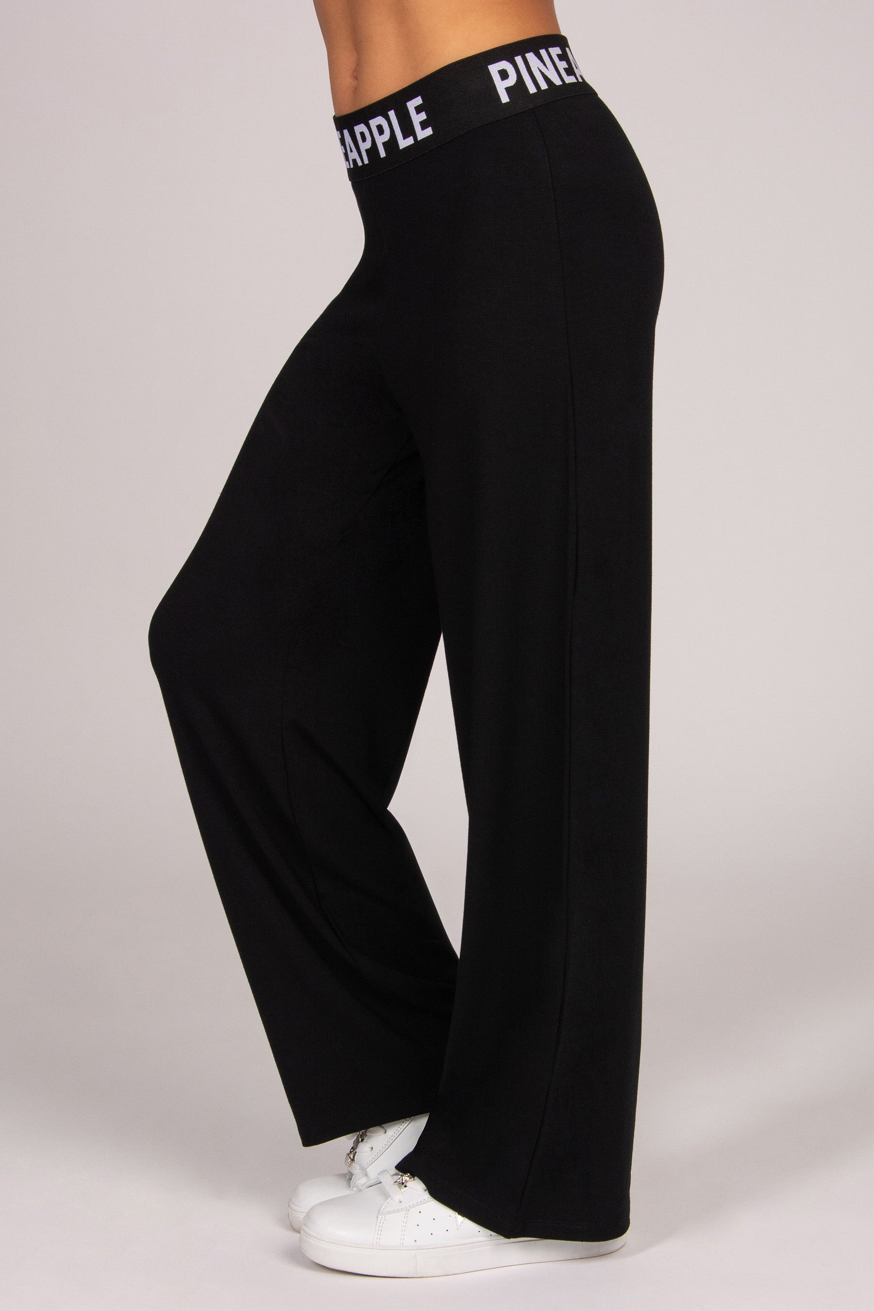 Black wide-leg viscose trousers with an elasticated waistband on a plain background
