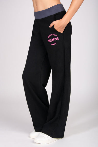 Black wide leg trousers with pink branding on a white background