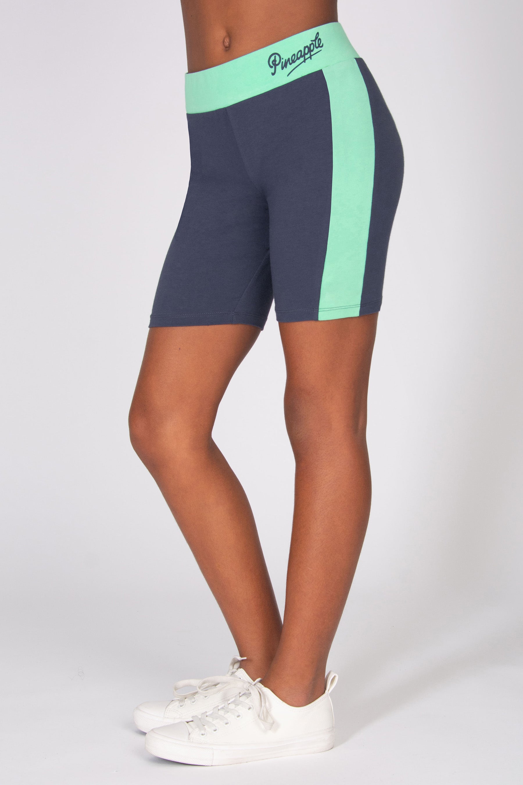 Dark grey cycling shorts with mint green side panels and contrast waistband on a white background