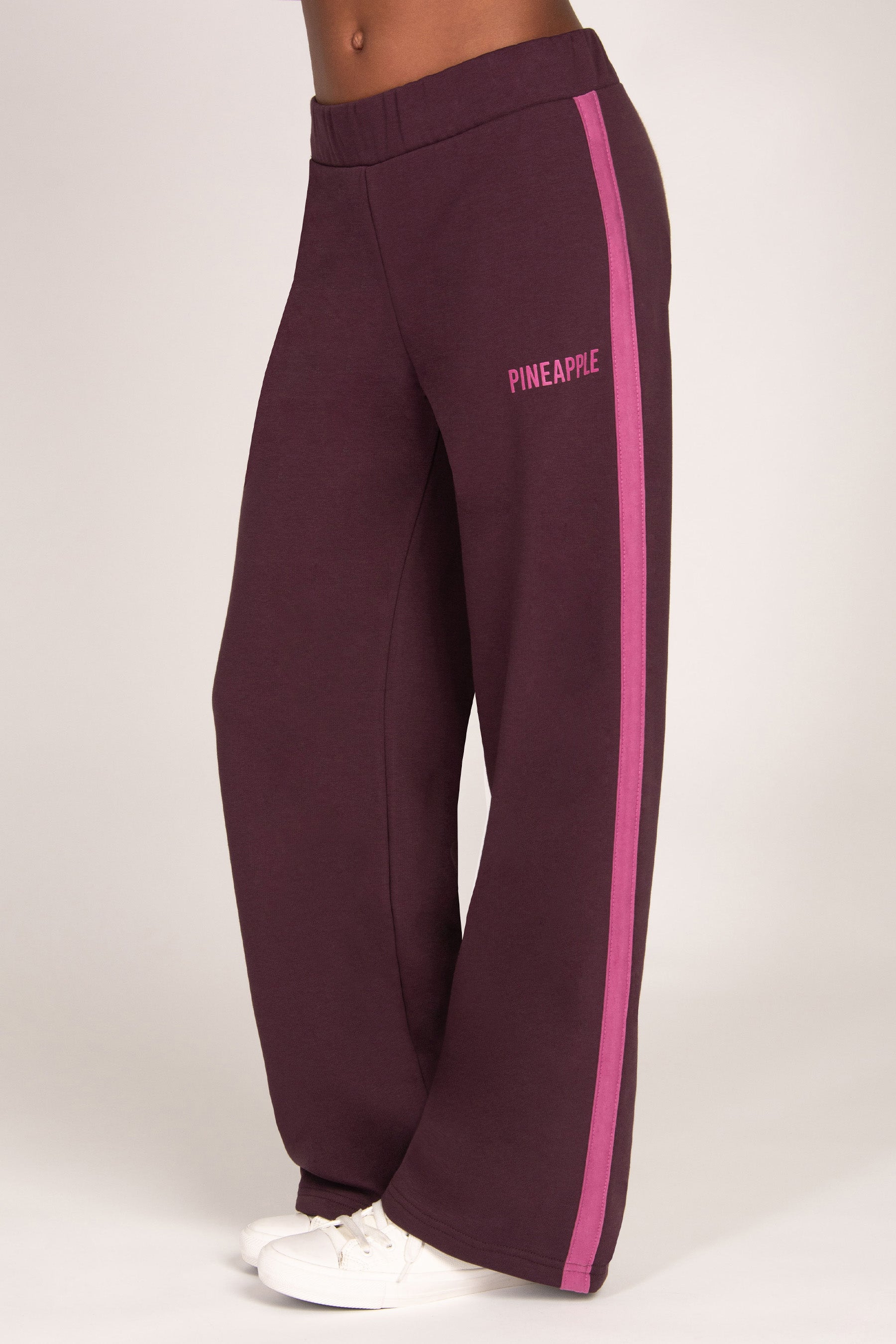 Maroon brown trousers with pink side panel and 'Pineapple' branding on a white background