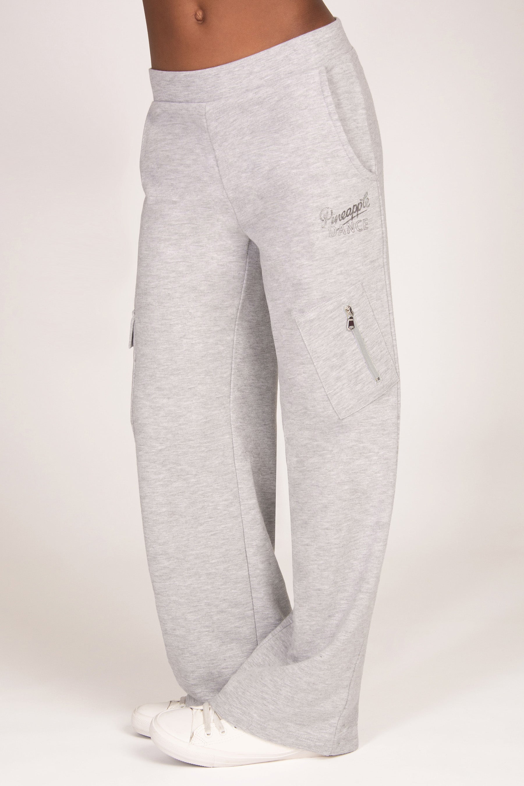 Light grey sweatpants with a zippered cargo pocket on the left leg and a small foil logo on the right thigh, shown on a model from the waist down against a plain light background.