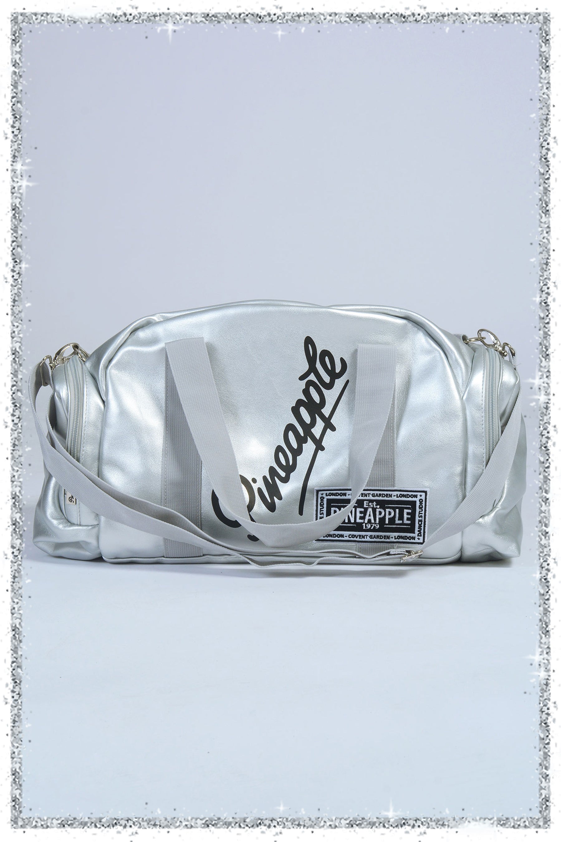 Silver crossbody bag with 'pineapple' branding on a light gray background