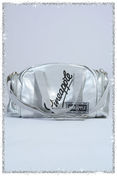 Silver crossbody bag with 'pineapple' branding on a light gray background