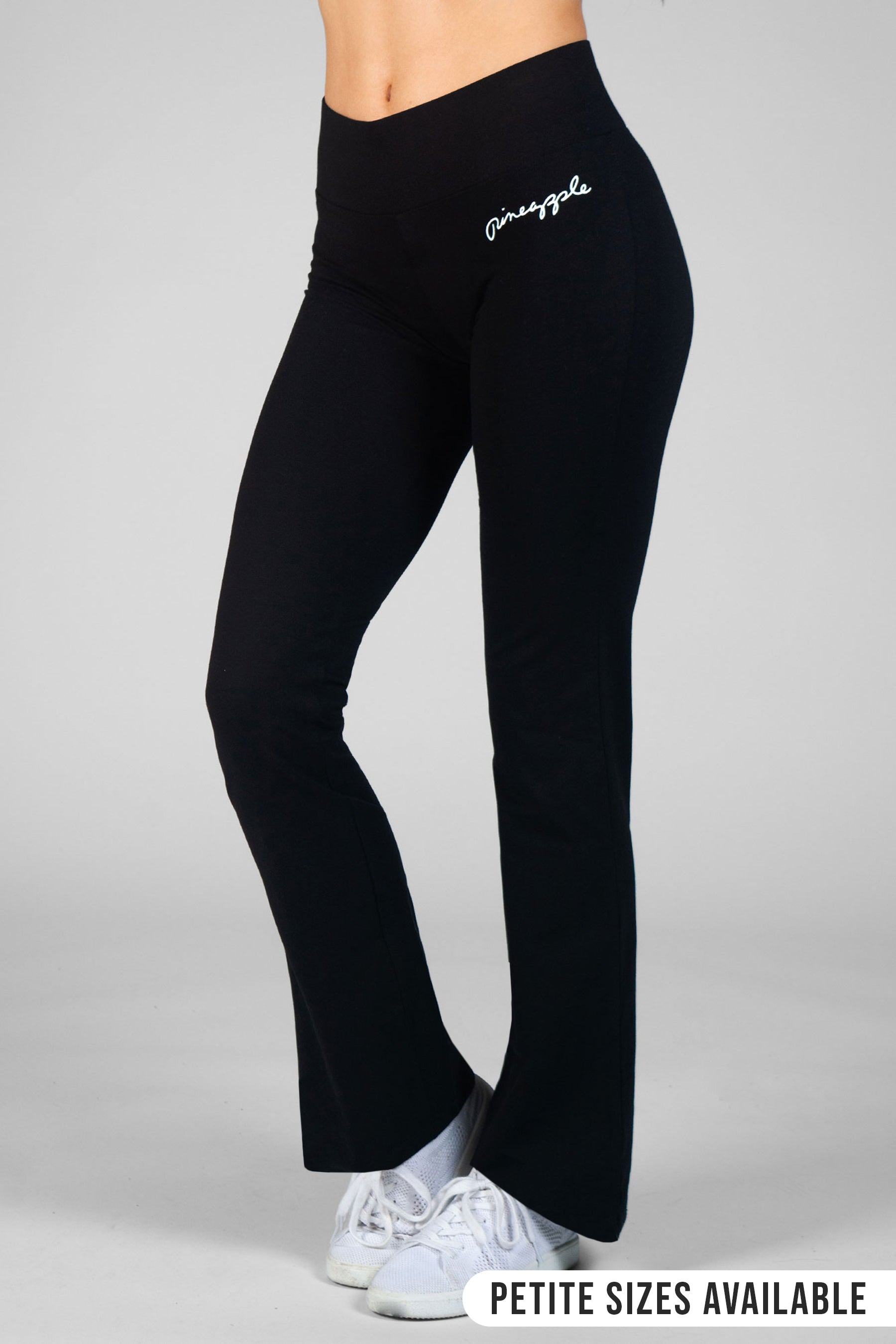 Woman wearing Pineapple black bootcut jersey yoga pants on a grey background
