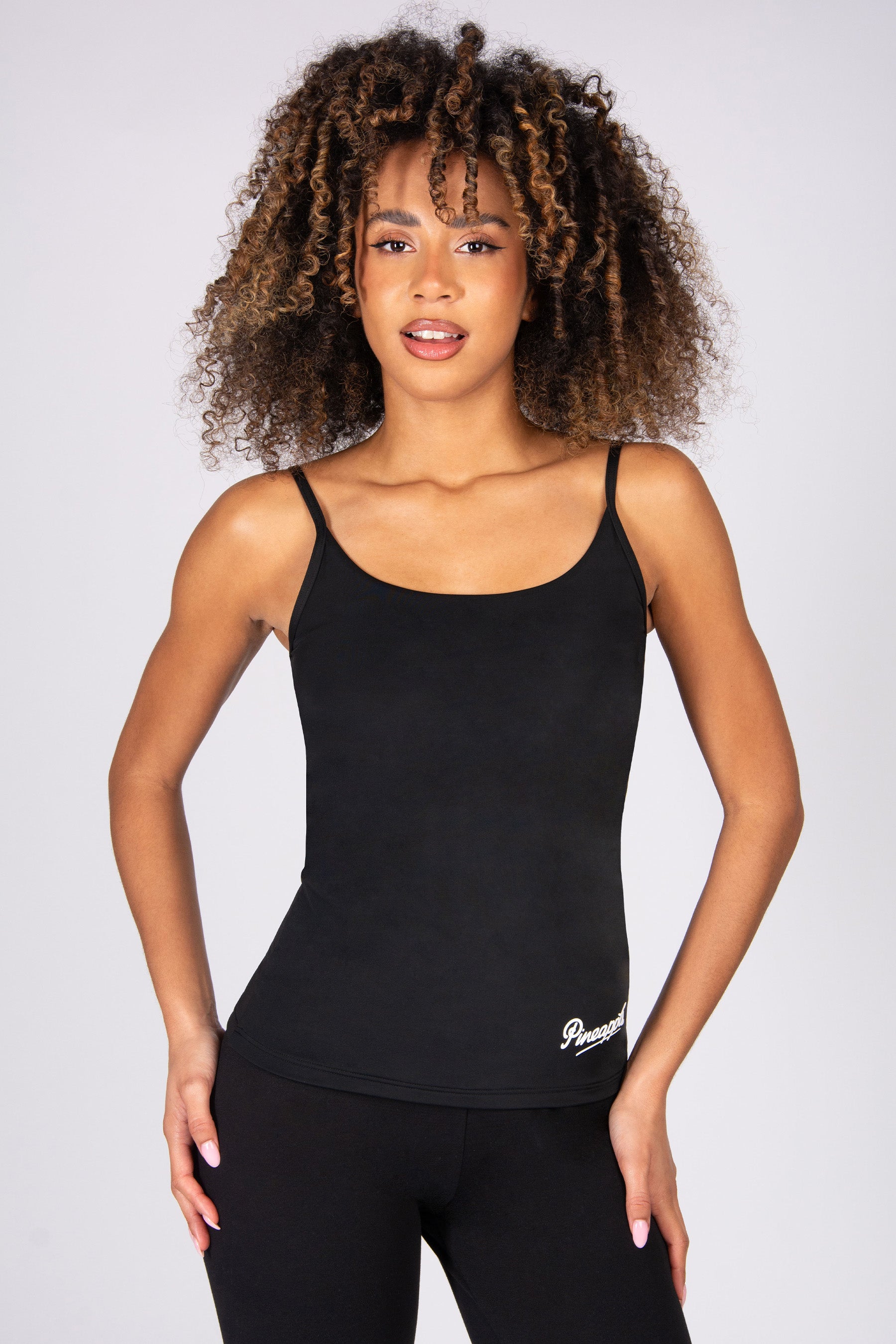 Woman wearing a black tank top on a plain background