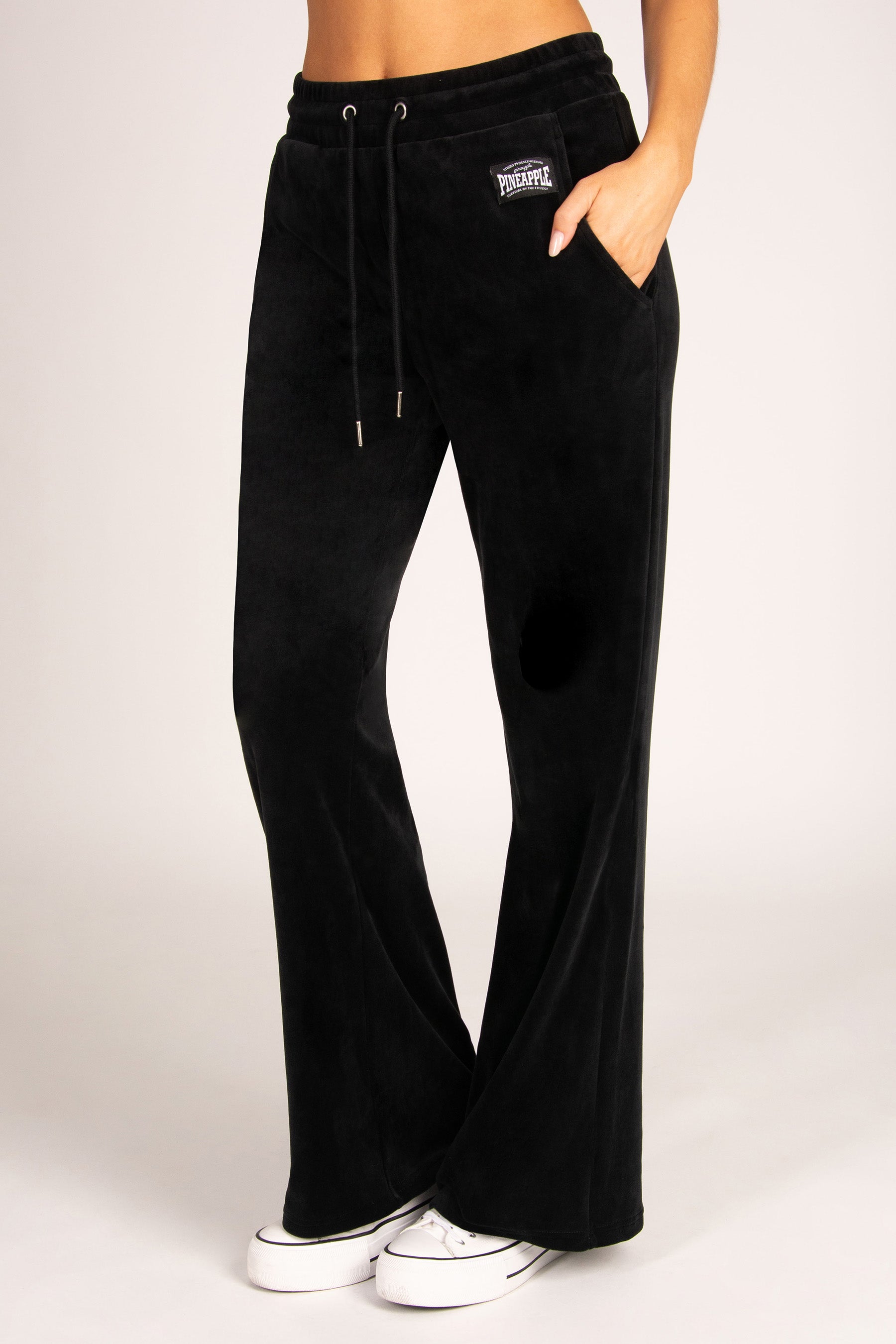 Black wide-leg viscose pants with a drawstring waist and side pockets, shown on a model against a light grey studio background.