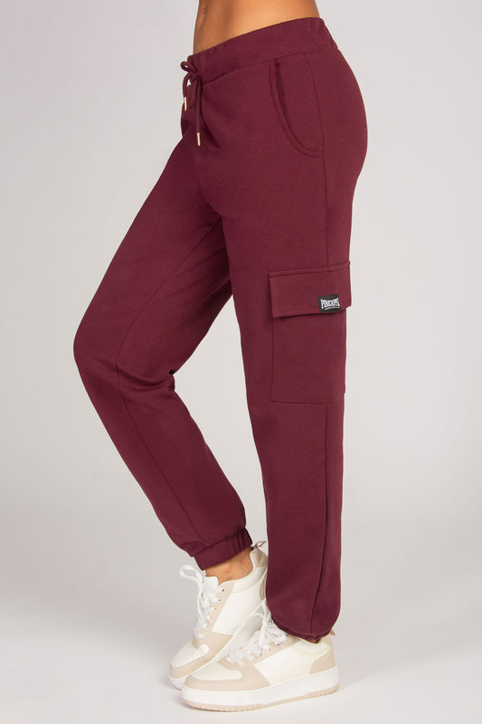 Maroon cargo pants with pockets worn by a person on a white background