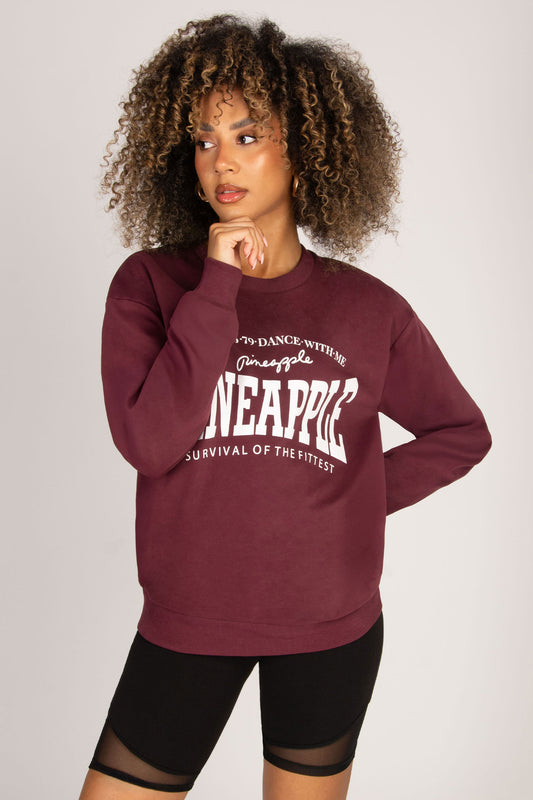 Burgundy oversized sweatshirt with large white logo print across the chest