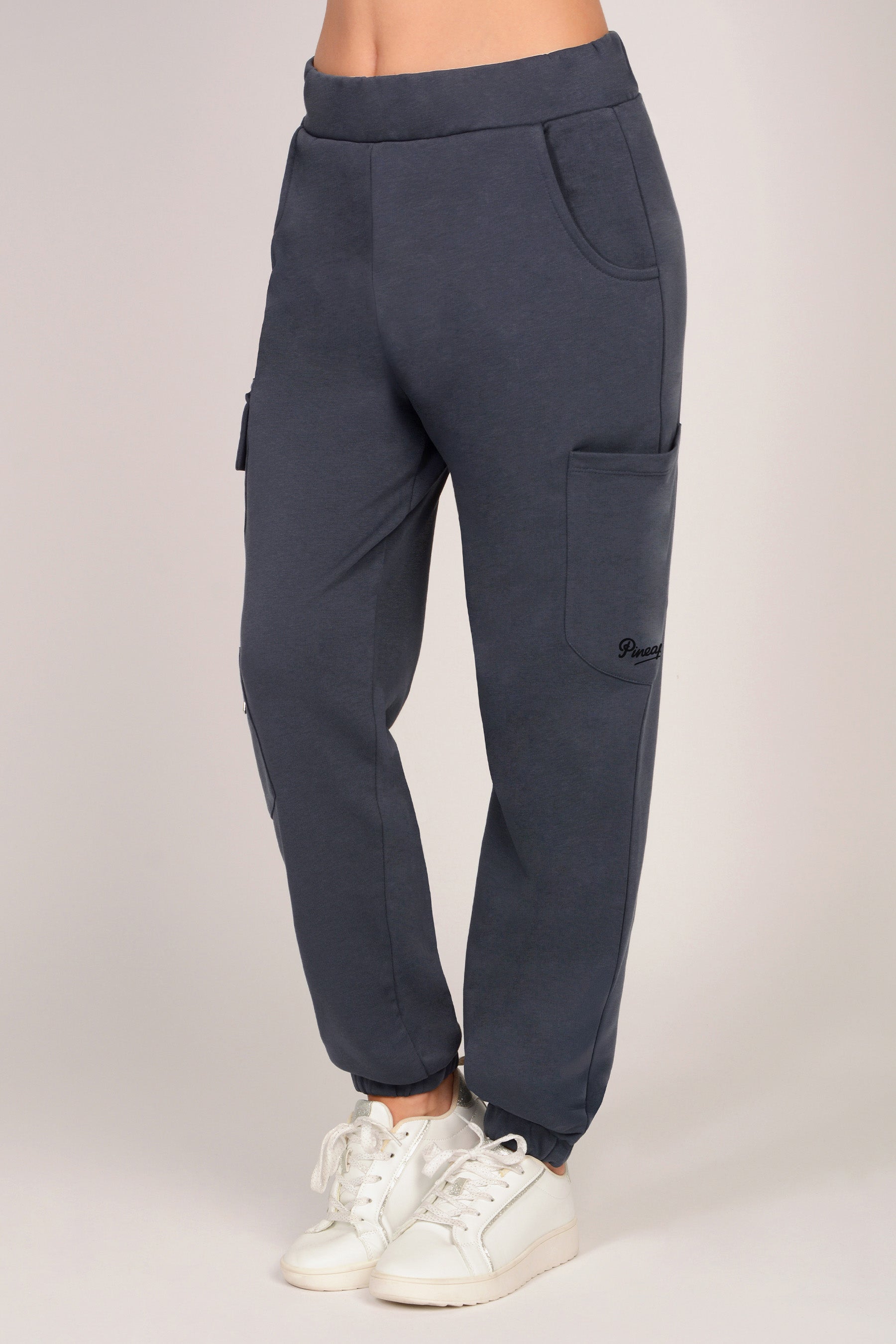 Women's dark grey combat joggers with pockets and elasticated waistband against a plain grey background. 