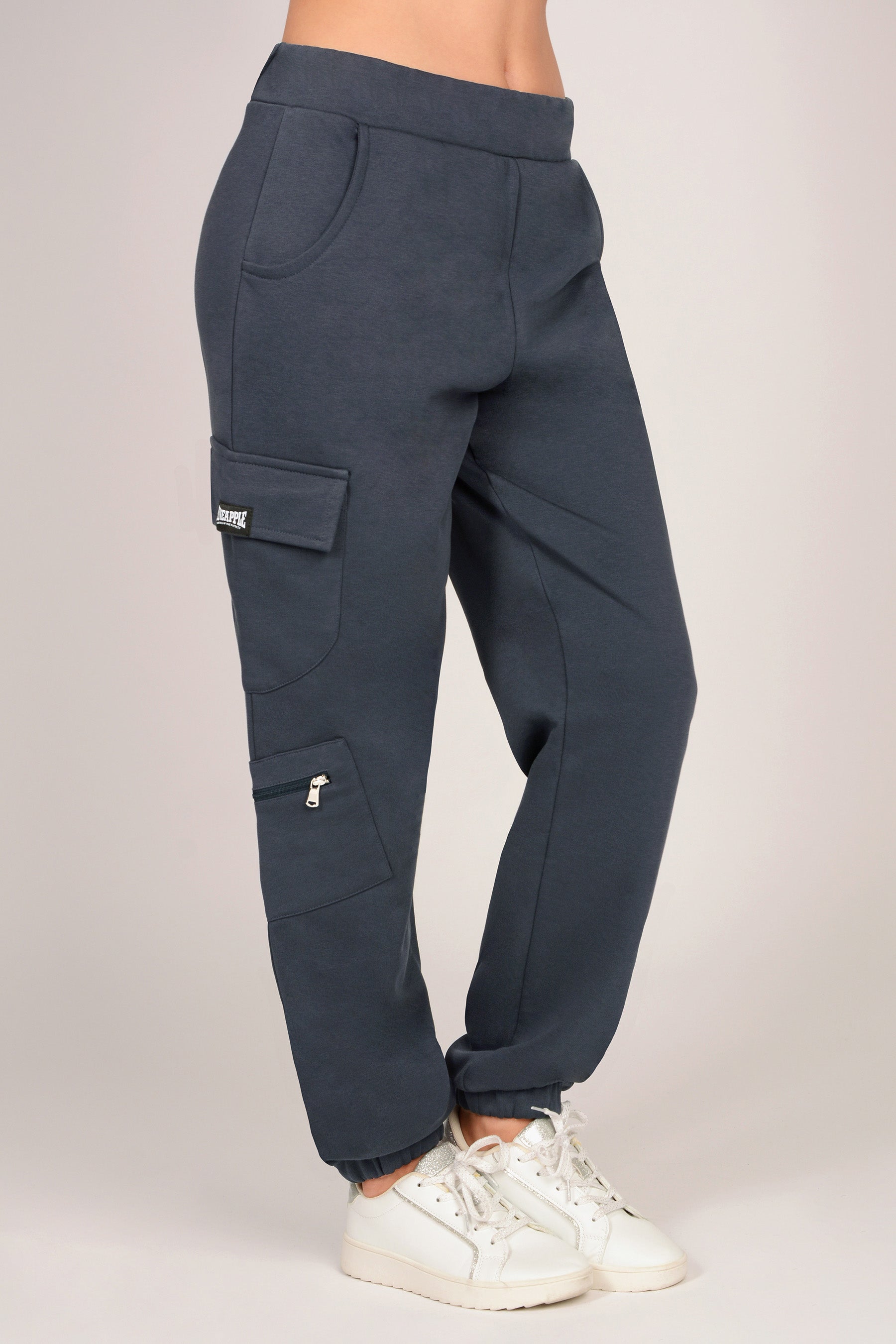 Women's dark grey combat joggers with pockets and elasticated waistband against a plain grey background. 