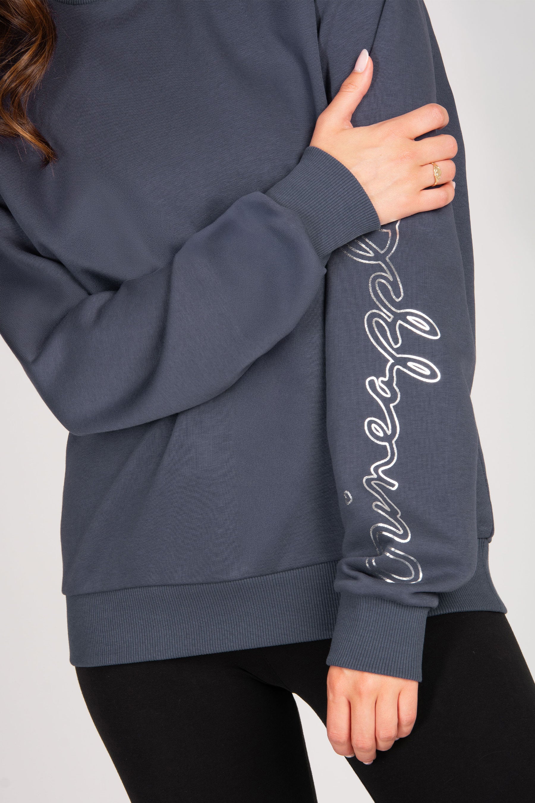 Navy blue sweatshirt with silver text on sleeve against a plain background