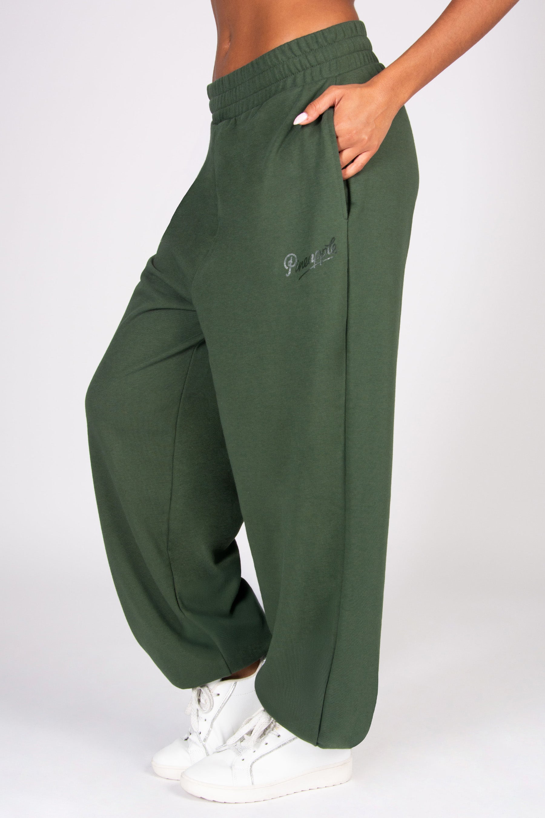 Khaki oversized sweatpants with pockets worn by a person on a white background