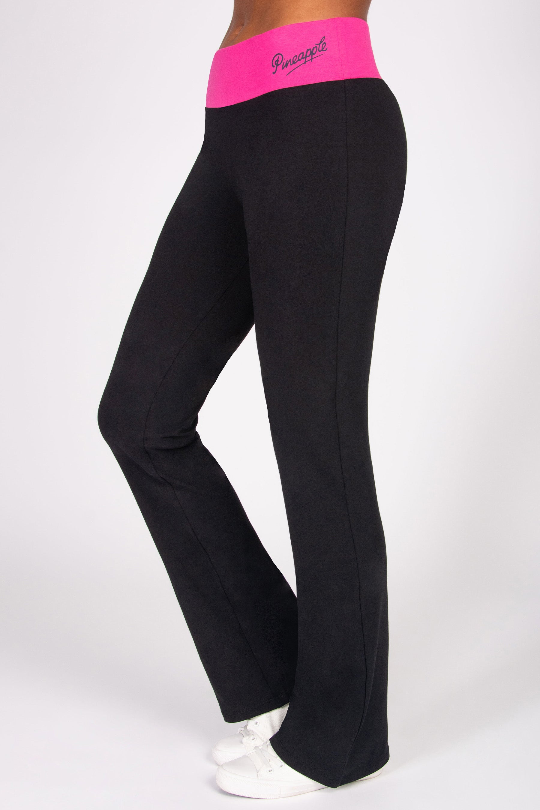 Black flared yoga pants with pink waistband featuring a brand logo on a white background
