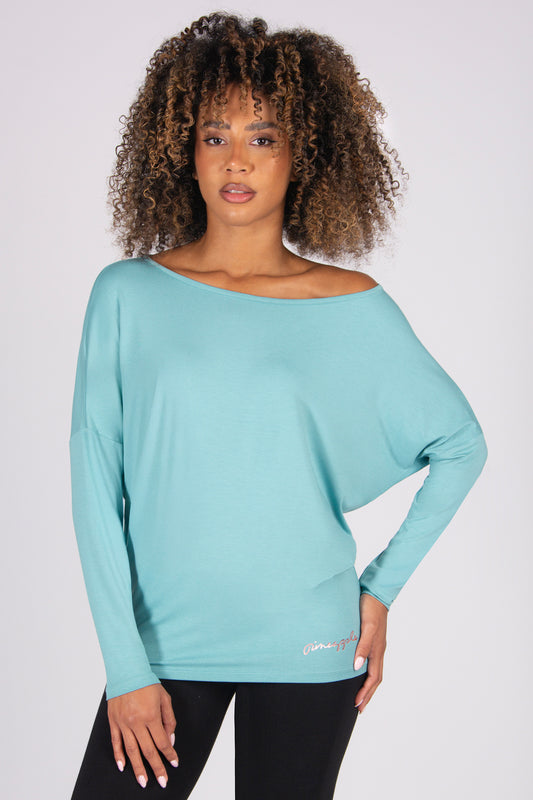 Woman wearing a light blue long-sleeve batwing top on a white background