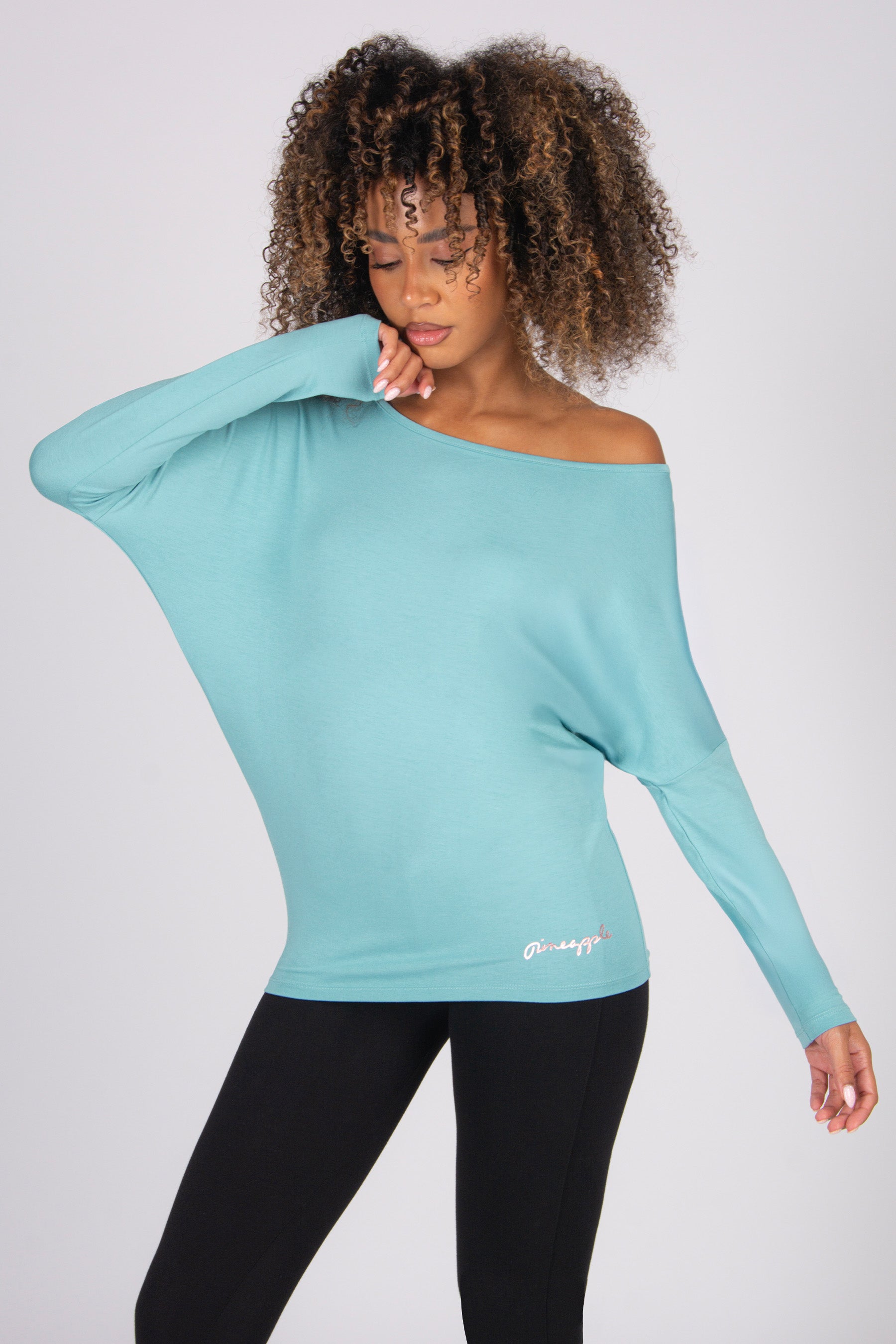 Woman wearing a light blue off-shoulder long sleeve top on a white background