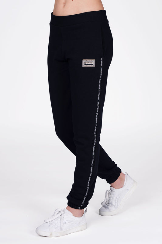 Girl wearing Pineapple Black Tape Joggers with white stripe, cropped side view